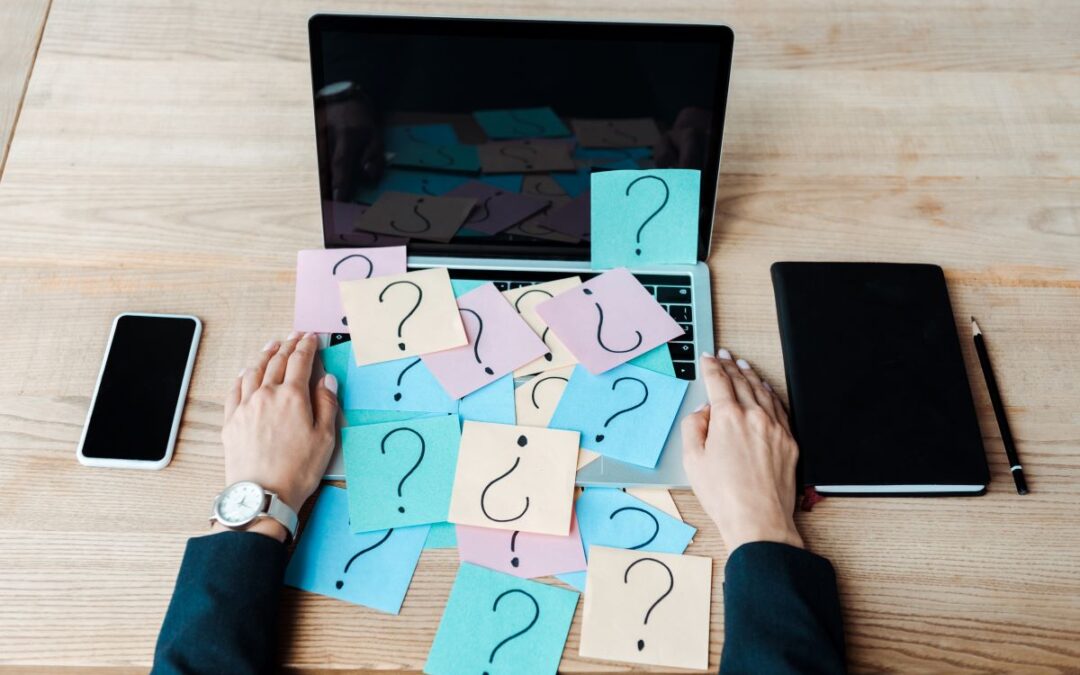 cropped view of women near sticky notes with question marks on a laptop for article The Difference Between Revocable and Irrevocable Trusts by kelley way